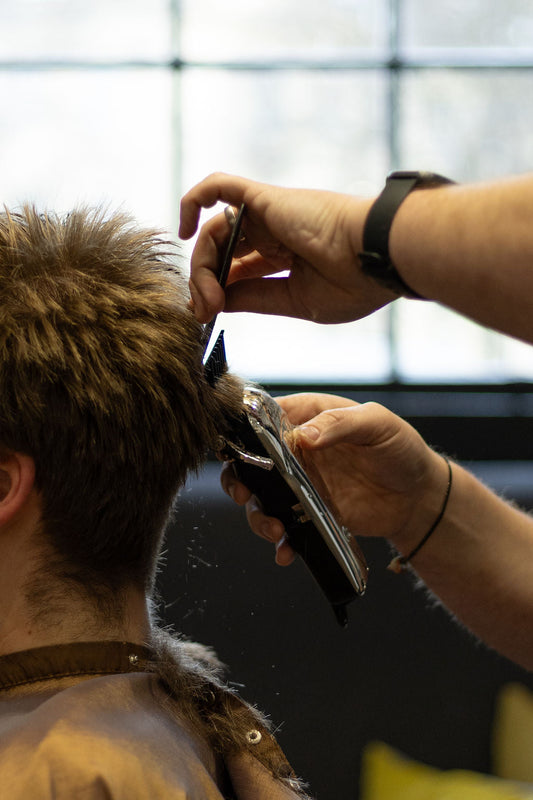 Man running hands through short styled hair — textured crop with matte finish | Hardwick Barbers Bath